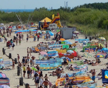 Piaszczysta plaża, zaś w tle coś dla najmłodszych - dmuchana zjeżdżalnia.